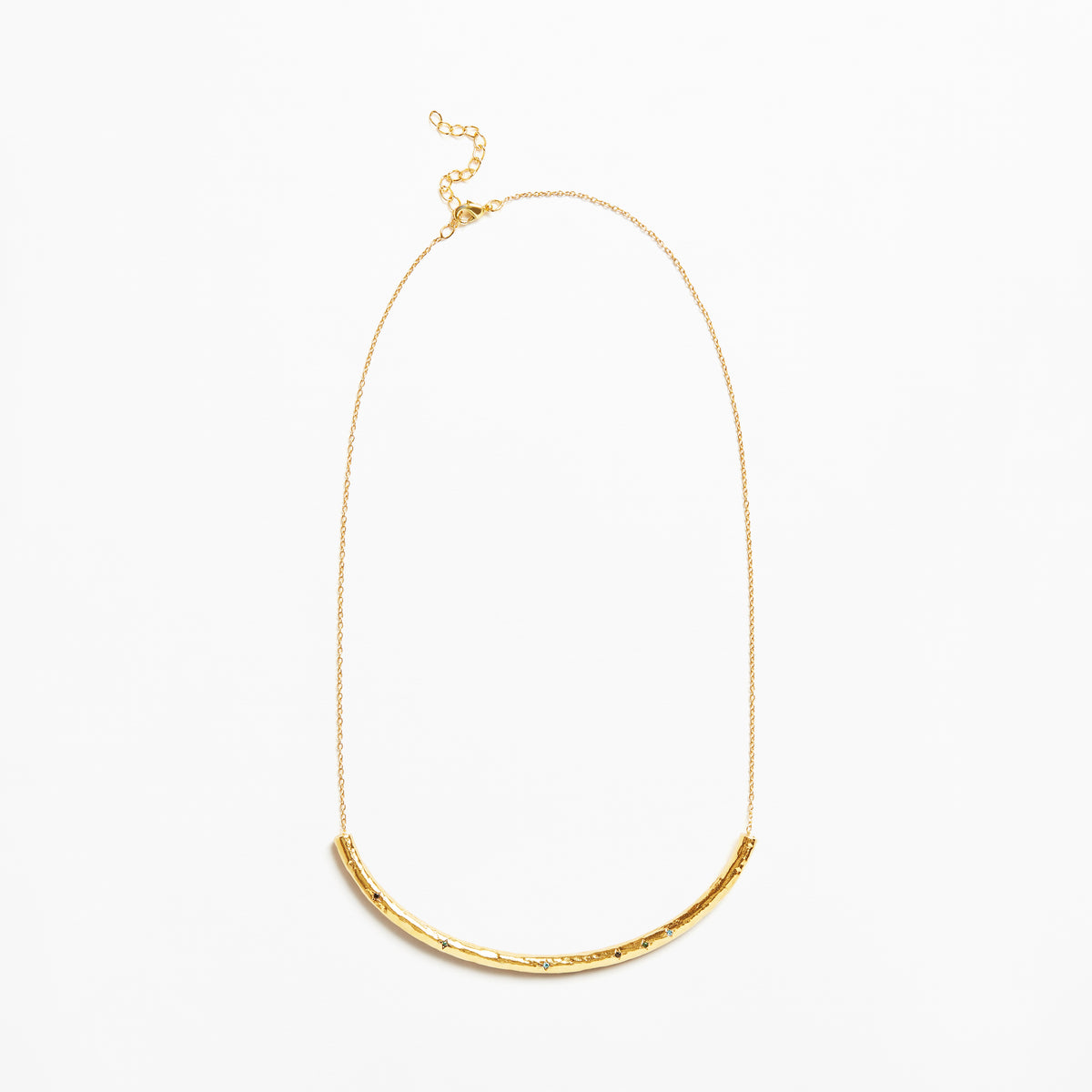 A delicate gold chain necklace featuring a textured, curved bar pendant at the bottom, displayed against a clean white background.
