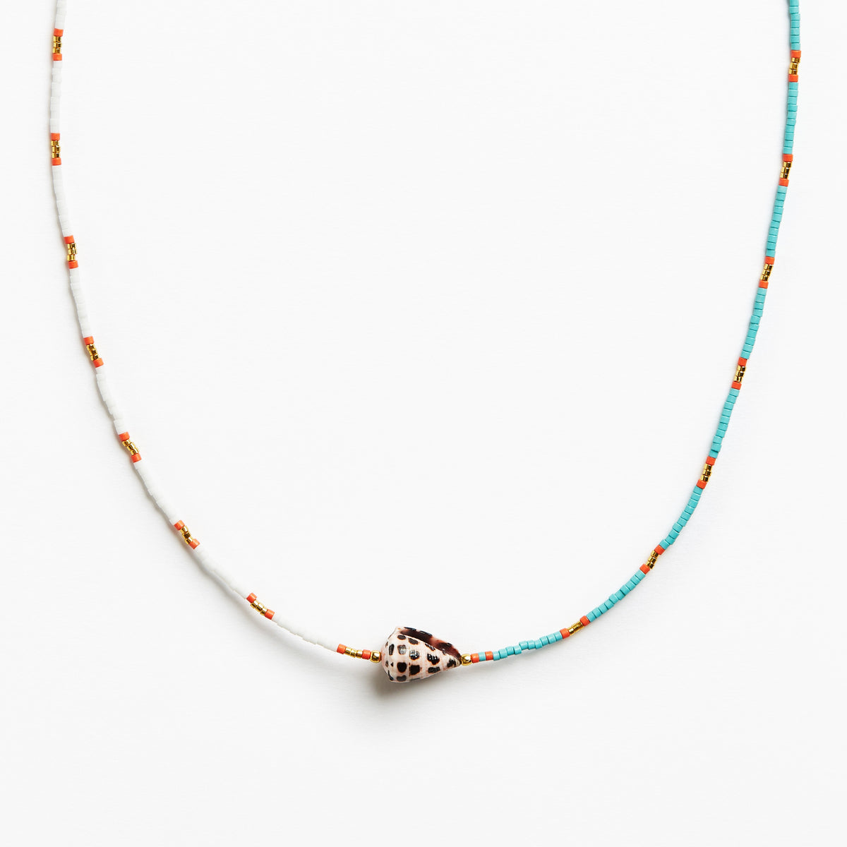 A delicate beaded necklace featuring turquoise blue and white beads with small orange accents, centered with a natural cowrie shell pendant on a clean white background.