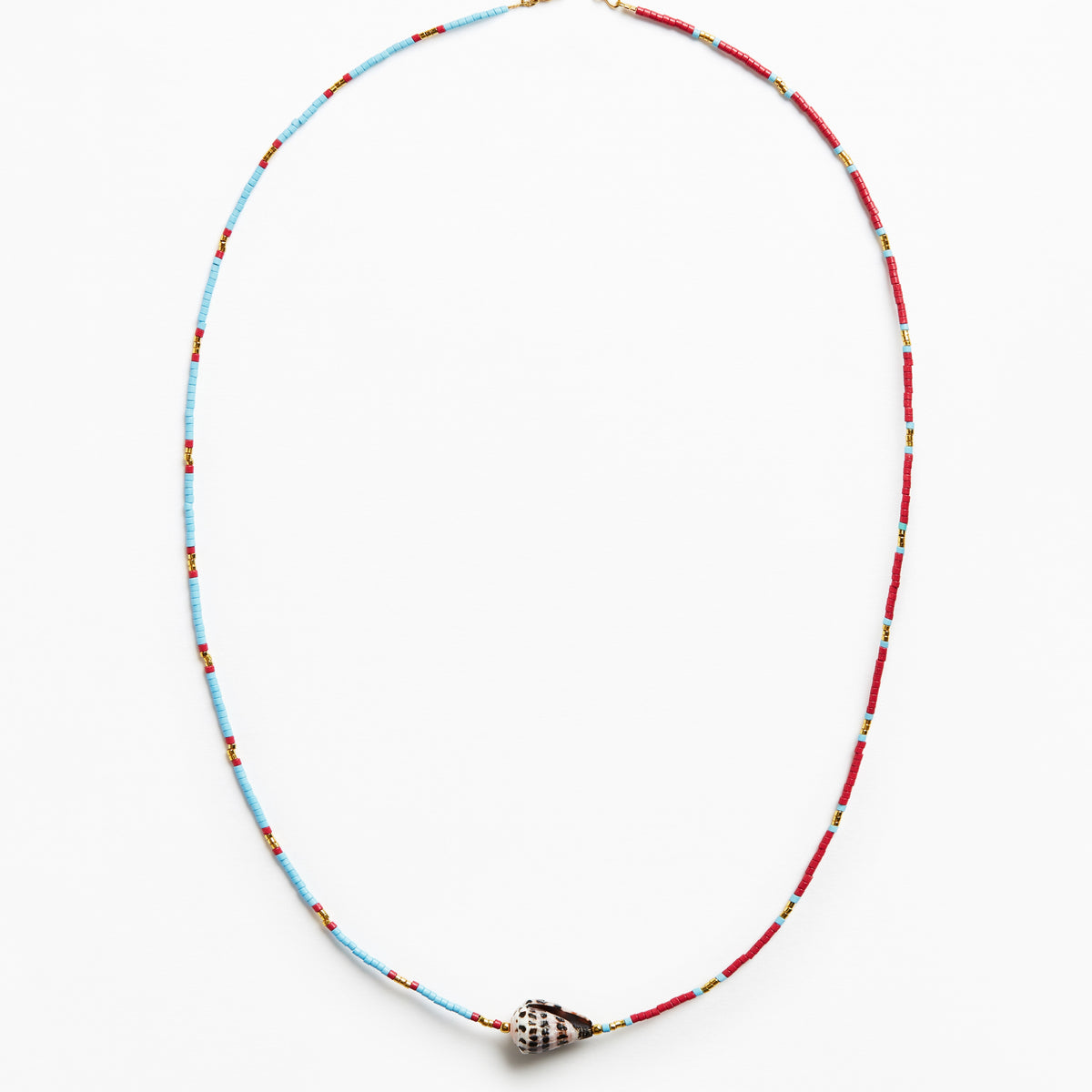 A delicate beaded necklace with alternating light blue and red beads, featuring a small metallic shell-shaped charm at the center, displayed on a clean white background.