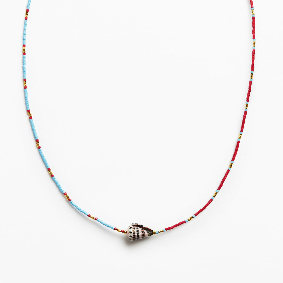 A beaded necklace featuring a light blue and red string with small yellow accents, finished with a silver conch shell pendant, shown against a plain white background.