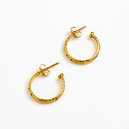 A pair of textured gold hoop earrings with post backs, displayed on a clean white background.