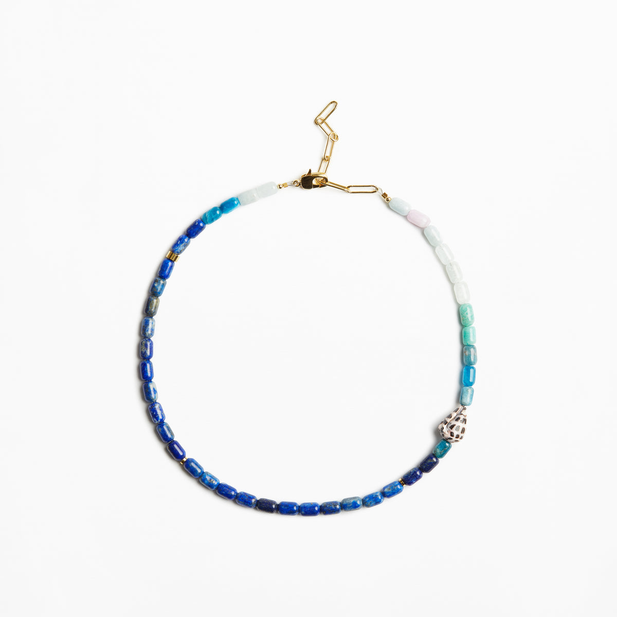 A beaded necklace with blue, teal, and white beads, accented by a small silver-toned skull charm and gold-toned clasp, shown on a plain white background.