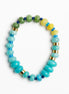 A beaded stretch bracelet featuring light blue and turquoise beads, green and yellow stone beads, and small gold spacer rings, displayed on a clean white background.