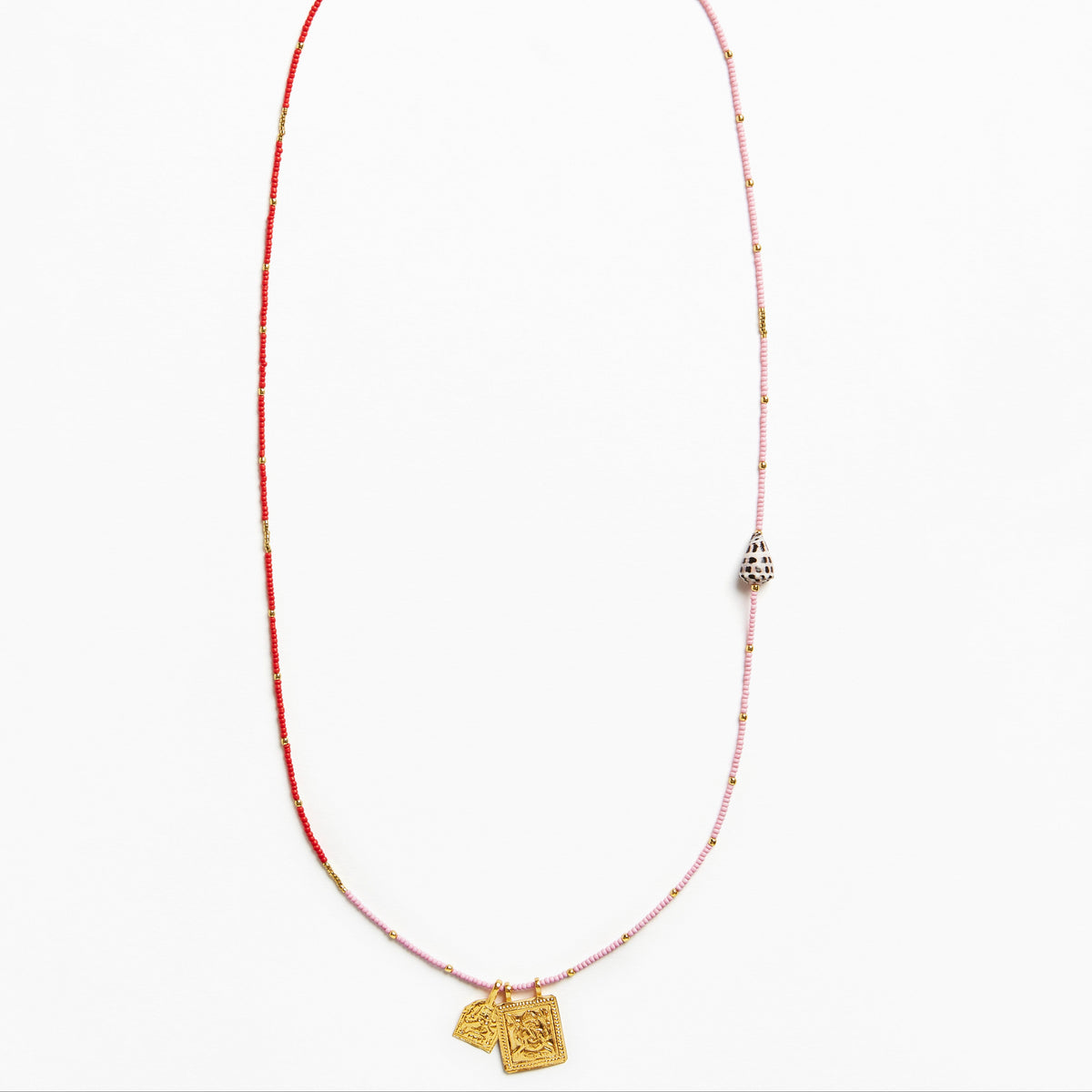 A delicate beaded necklace featuring a red and light pink string with small metallic beads, a silver-toned bell-shaped charm, and two gold-toned pendant tags at the bottom, displayed on a clean white background.