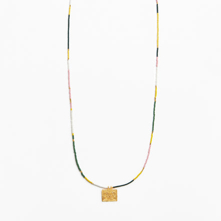A delicate beaded necklace with a textured gold square pendant, featuring small beads in yellow, green, pink, and white, displayed against a clean white background.