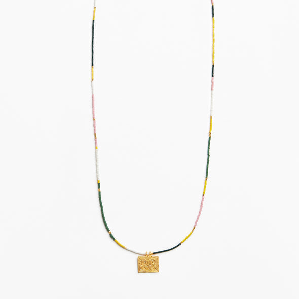 A delicate beaded necklace with a textured gold square pendant, featuring small beads in yellow, green, pink, and white, displayed against a clean white background.