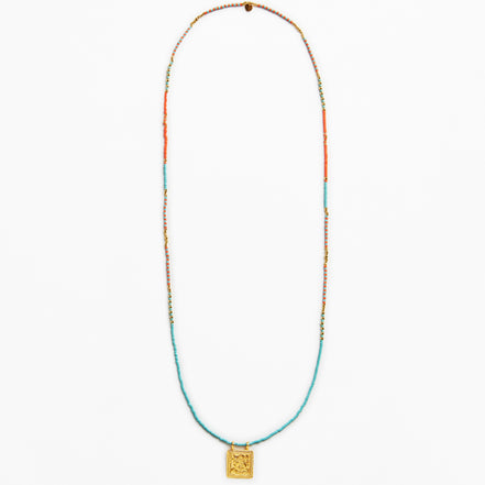 A long beaded necklace featuring turquoise blue, orange, and gold beads, with a square gold pendant at the bottom, displayed against a plain white background.