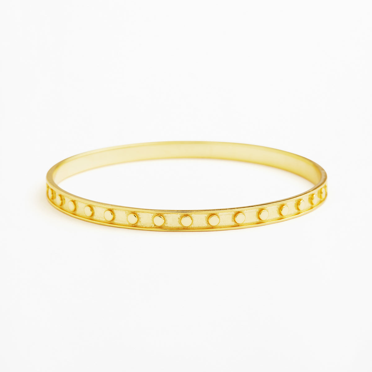 A thin yellow gold bangle bracelet with a row of small circular cutouts along the front, shown on a plain white background.