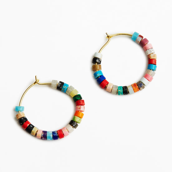 A pair of gold-tone hoop earrings decorated with small, colorful cylindrical beads in various patterns and colors, set against a plain white background.