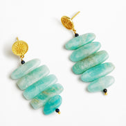 A pair of gold and turquoise drop earrings on a clean white background. Each earring features a textured gold post with a small black bead, followed by a cluster of elongated, rounded turquoise-blue beads.