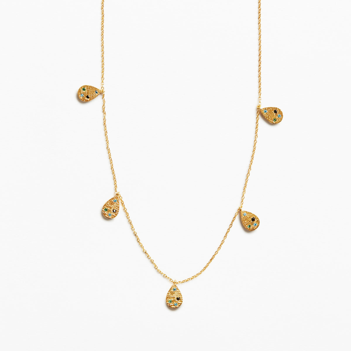 A delicate gold chain necklace featuring five small teardrop-shaped pendants, each decorated with tiny black and yellow inlay details, set against a plain white background.