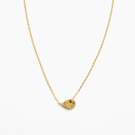 A delicate gold chain necklace featuring a small teardrop-shaped pendant adorned with tiny green and blue stones and a central black detail, set against a plain white background.